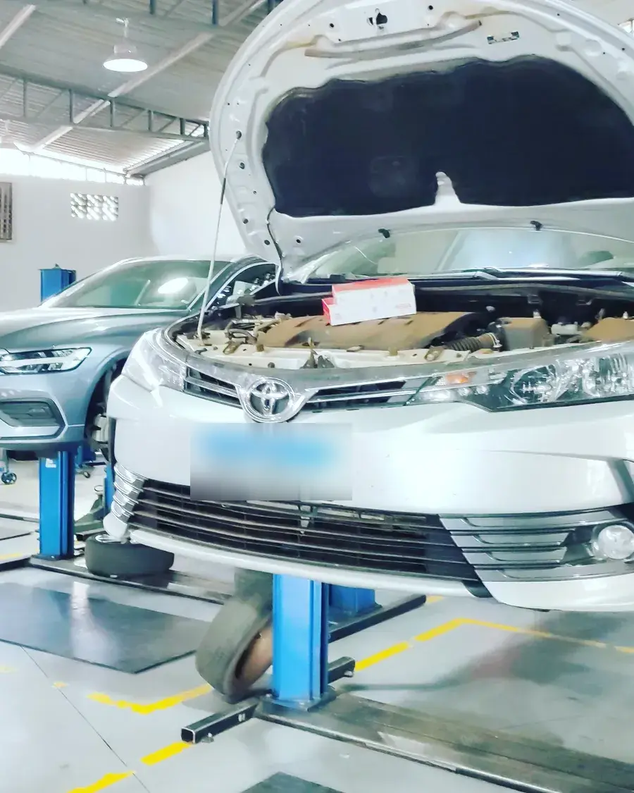 Carro no elevador com o capô aberto durante um serviço na Impacto Auto Center